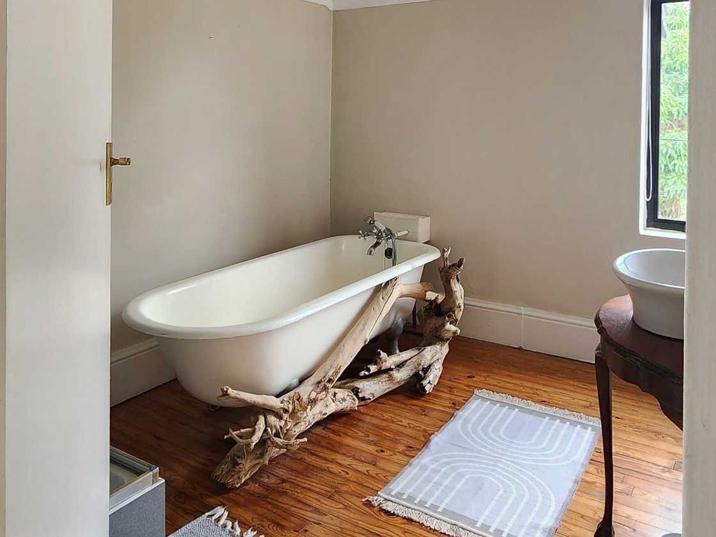 Bathroom with a claw-foot bath on driftwood